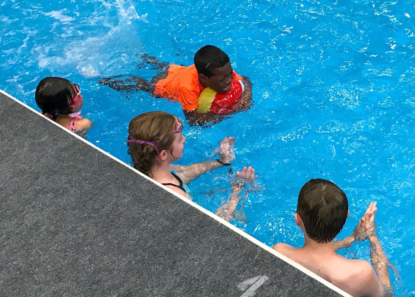 Campers using boogie boards to learn how to swim