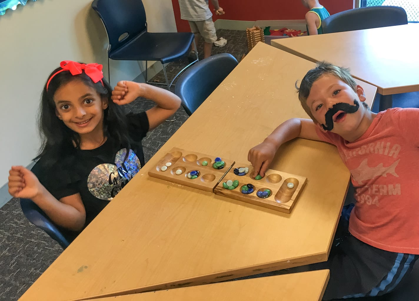 Kids playing mancala indoors