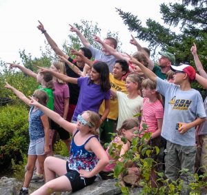 kids at camp pointing to the sky