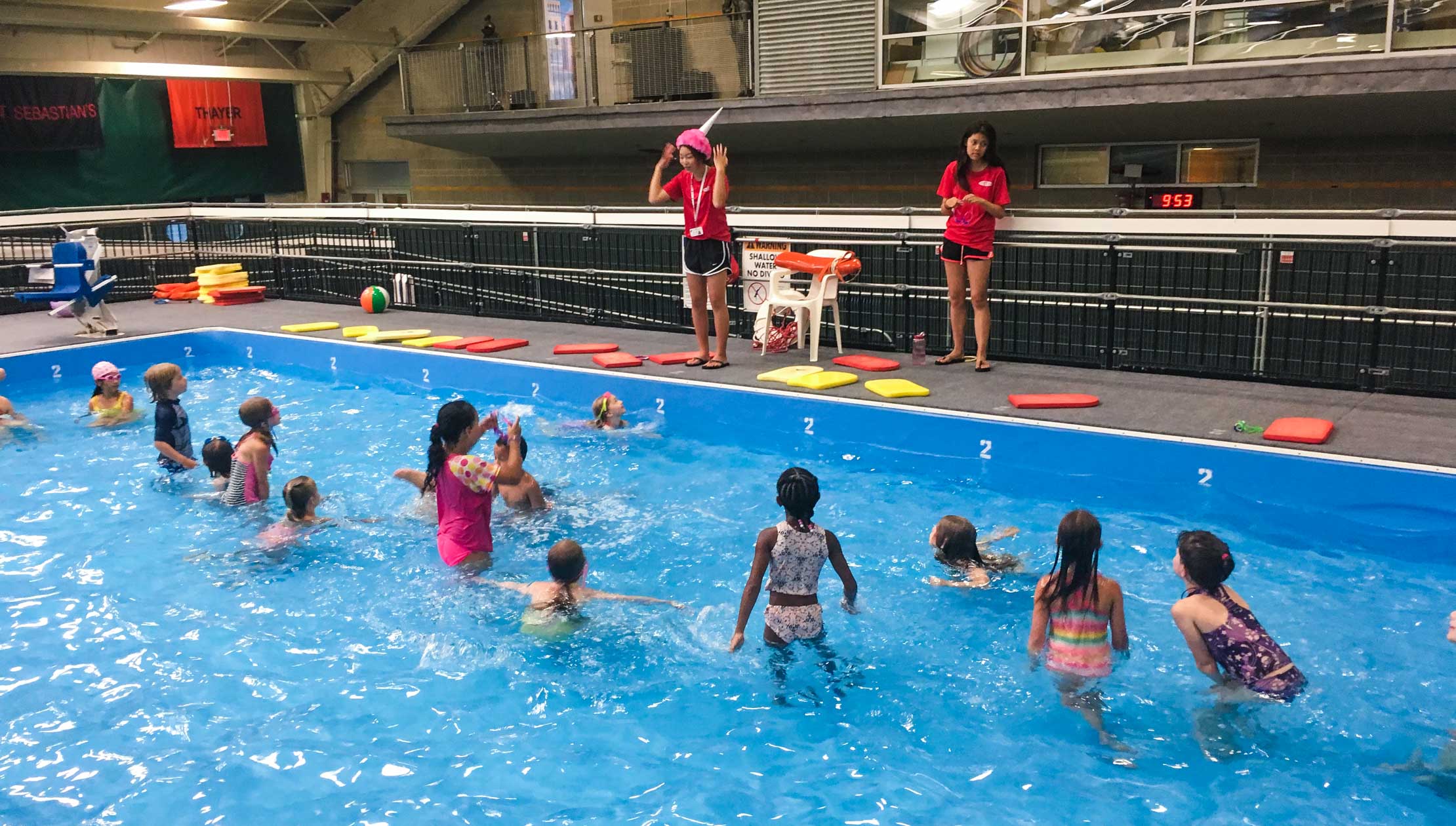 Lifeguards helping campers with swimming lessons